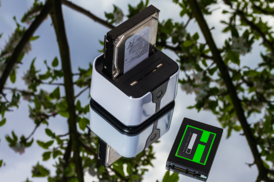 Adaptador para HD e SSD refletido em superfície.