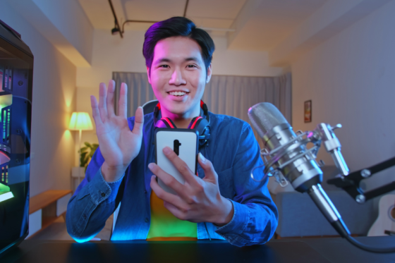 Homem sorrindo e gravando vídeo com smartphone